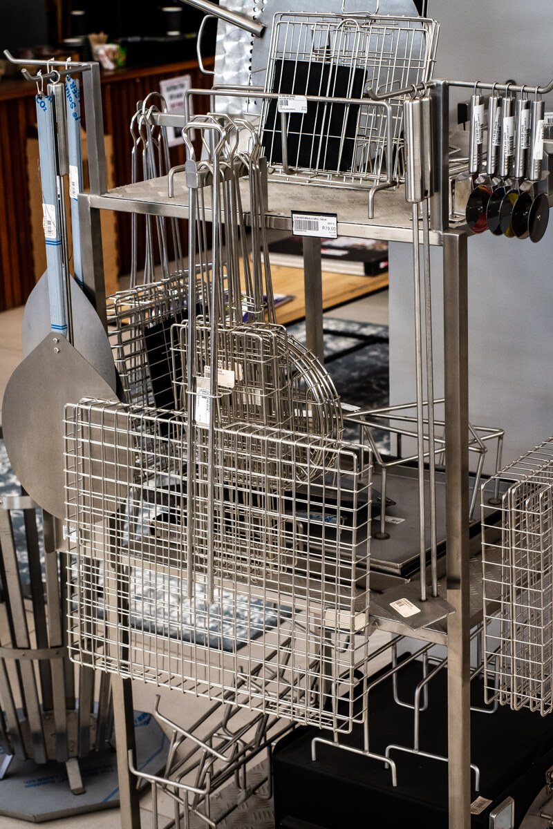 Stainless steel braai grids and accessories on a stand