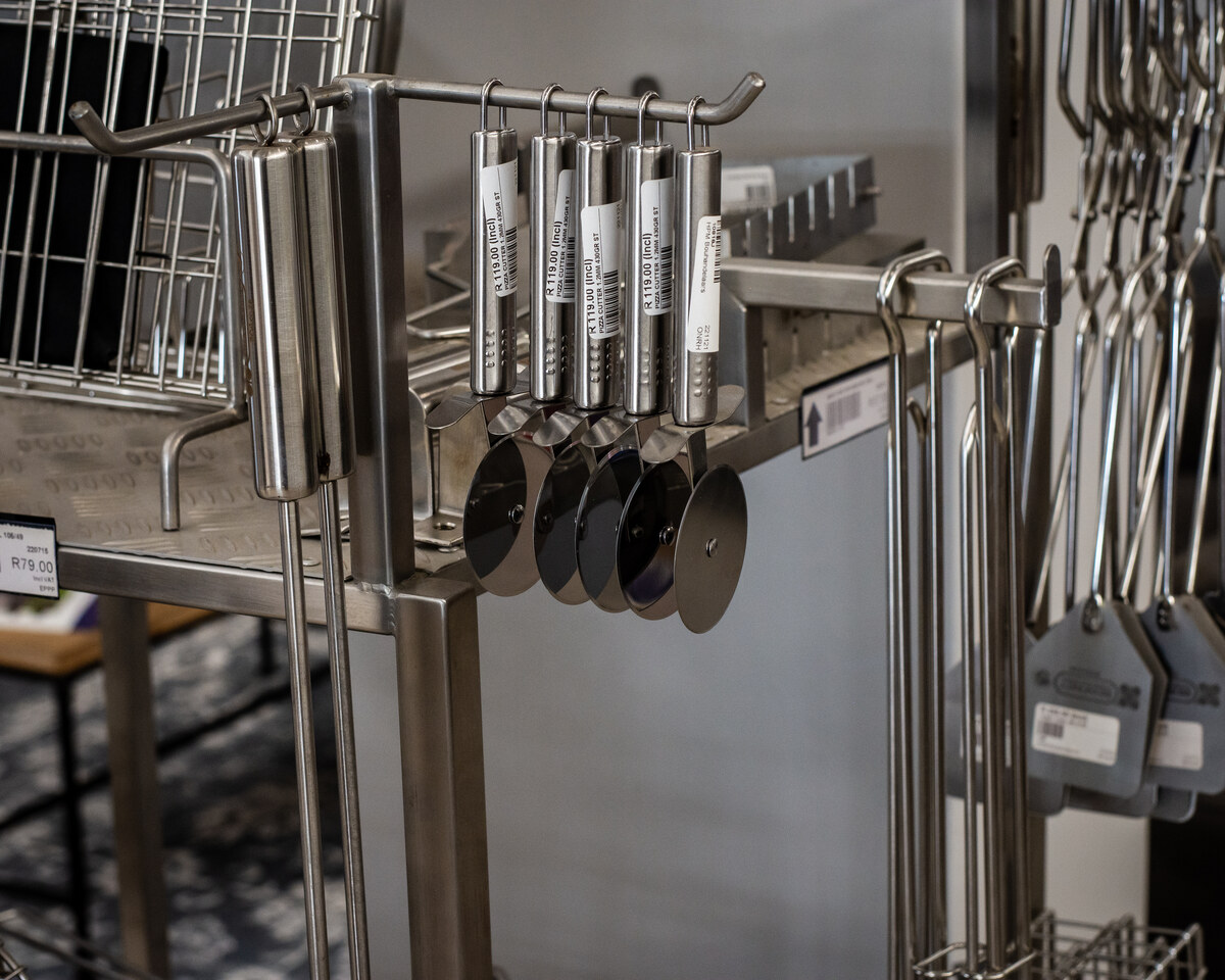 Stainless steel braai tools hanging on a rail