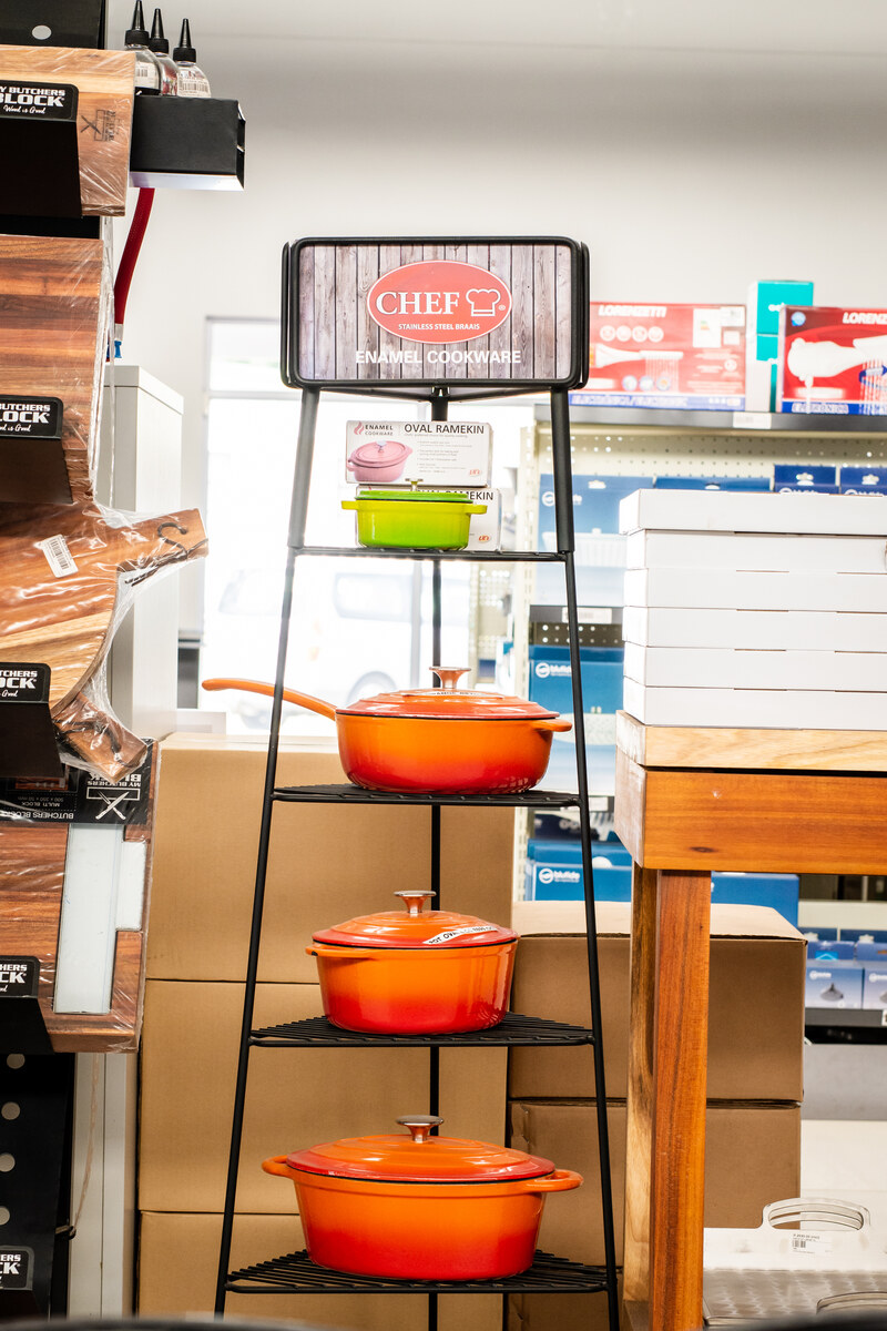 Cast-iron cookware in orange on a display stand