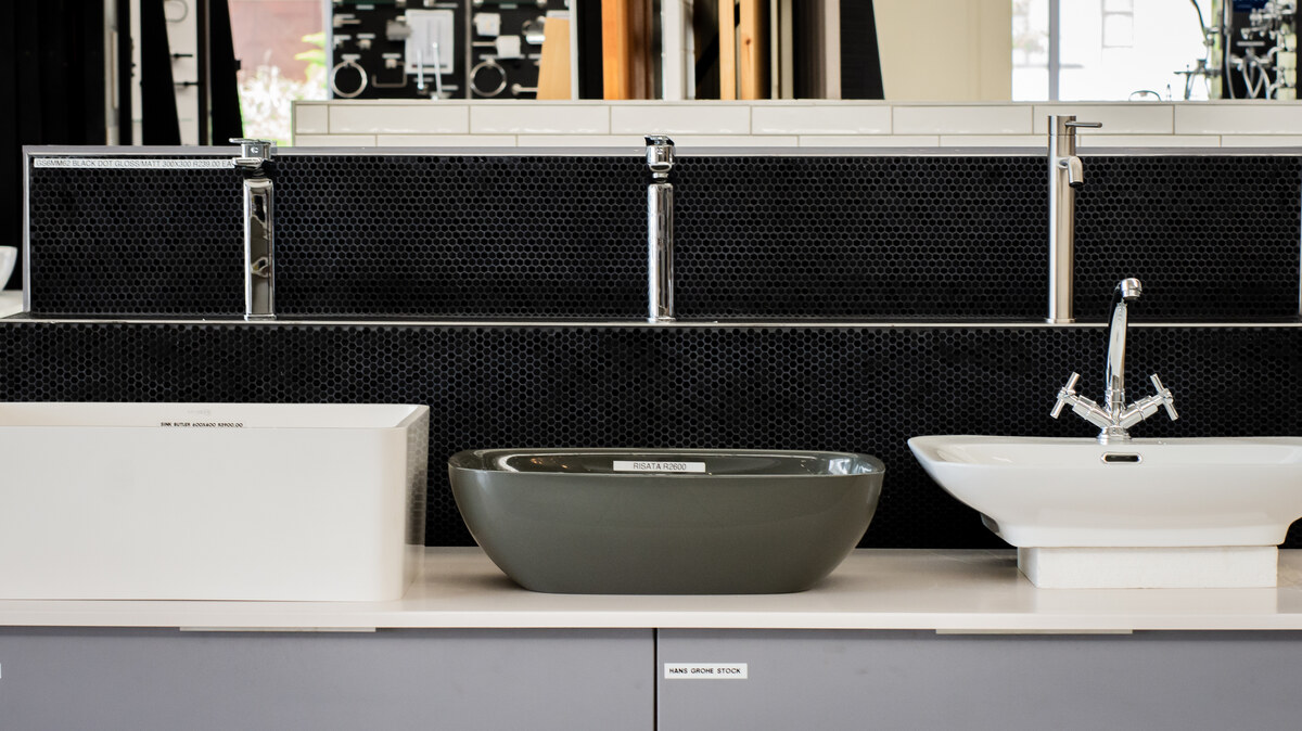 Vessel basins and mixer taps on a black mosaic vanity