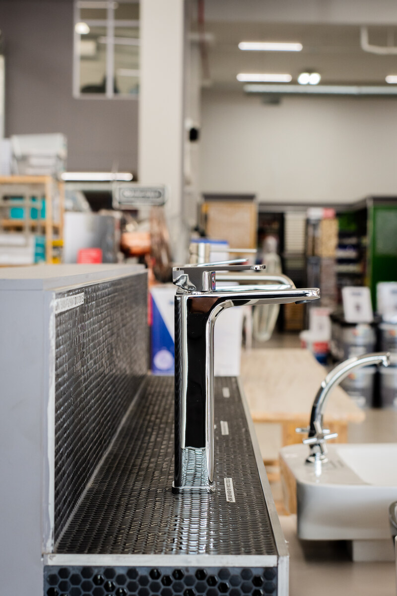 Bathroom showroom with mosaic-tiled vanity and taps