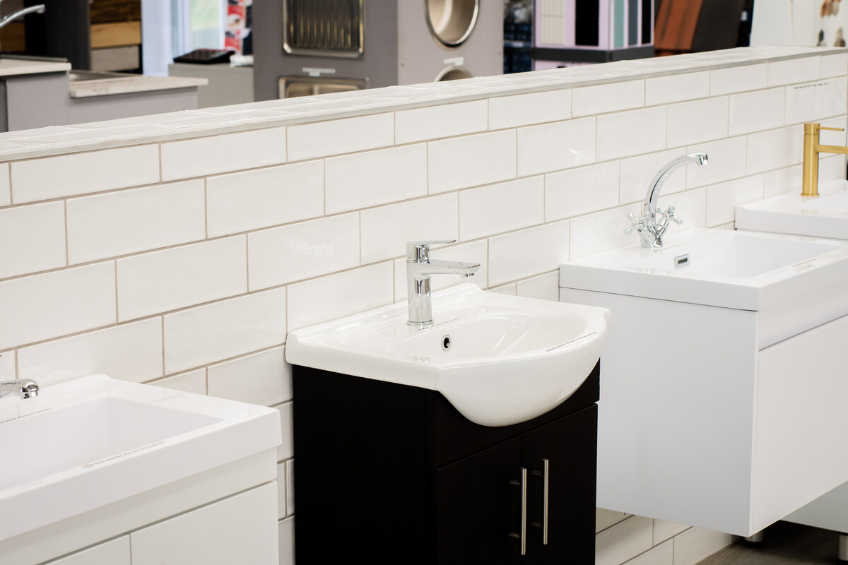 Basins and taps on white-tiled bathroom displays