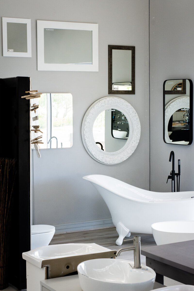 Bathroom display with a freestanding bath, basin and mirrors